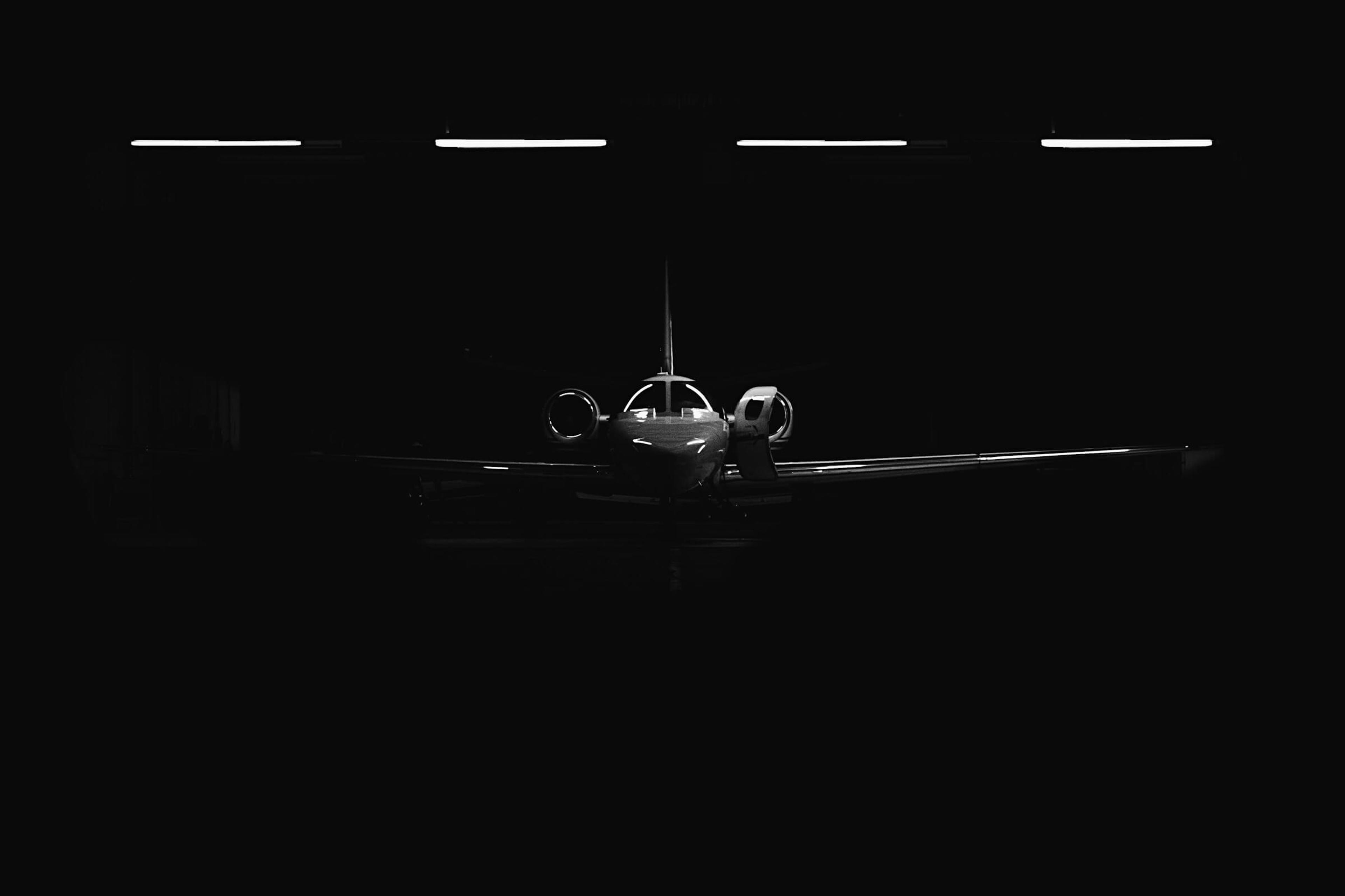 Private jet parked in an airplane hanger at night